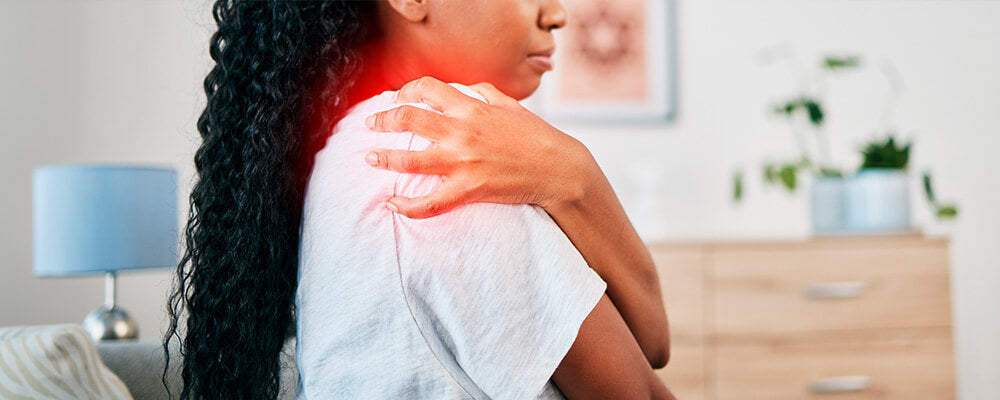 Mujer agarrándose el hombro adolorida