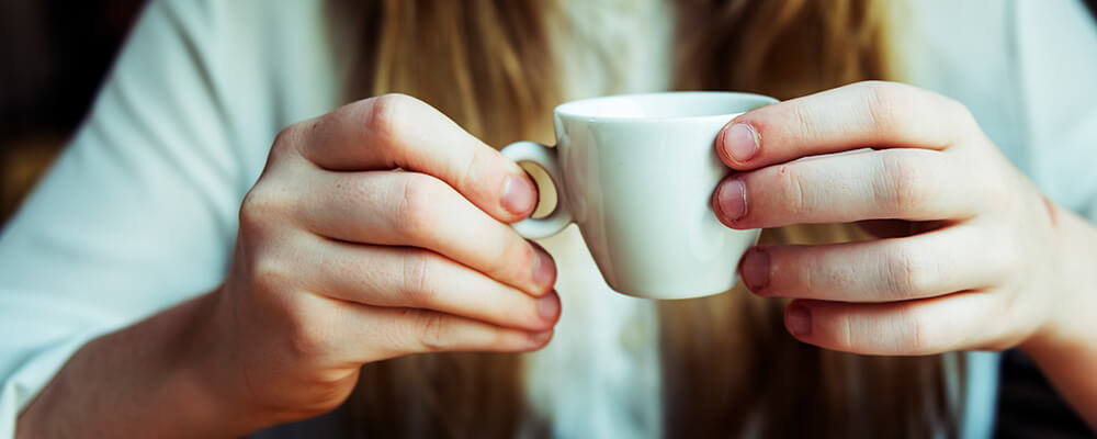 Manos de mujer con una taza de café