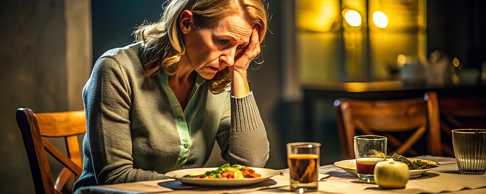 Mujer estresada en una mesa con comida