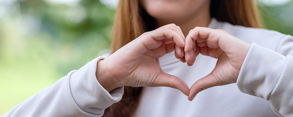 Manos de mujer haciendo un corazón