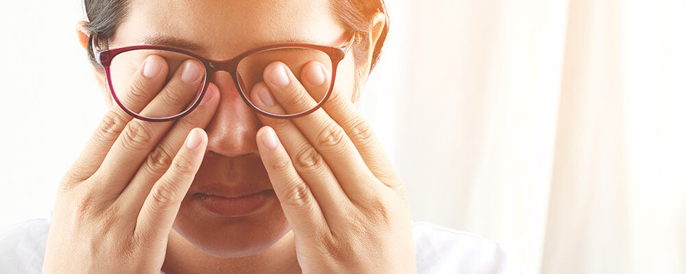 Mujer con lentes frotándose los ojos