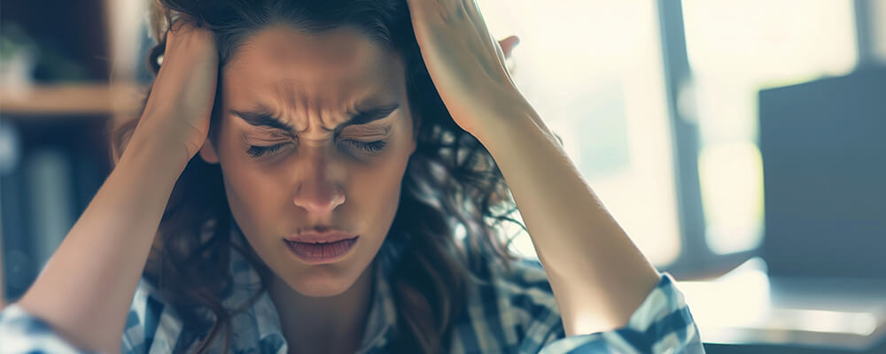 Cabeza de mujer agobiada con las manos en la cabeza